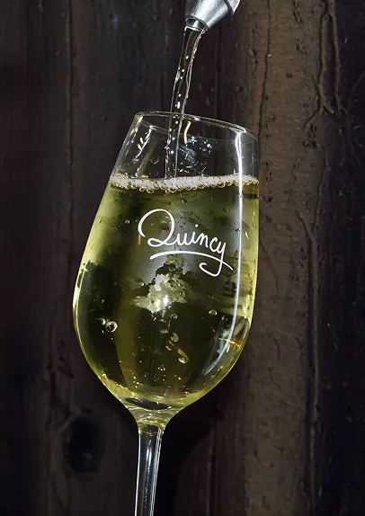 Vin blanc de Quincy versé dans un verre gravé
